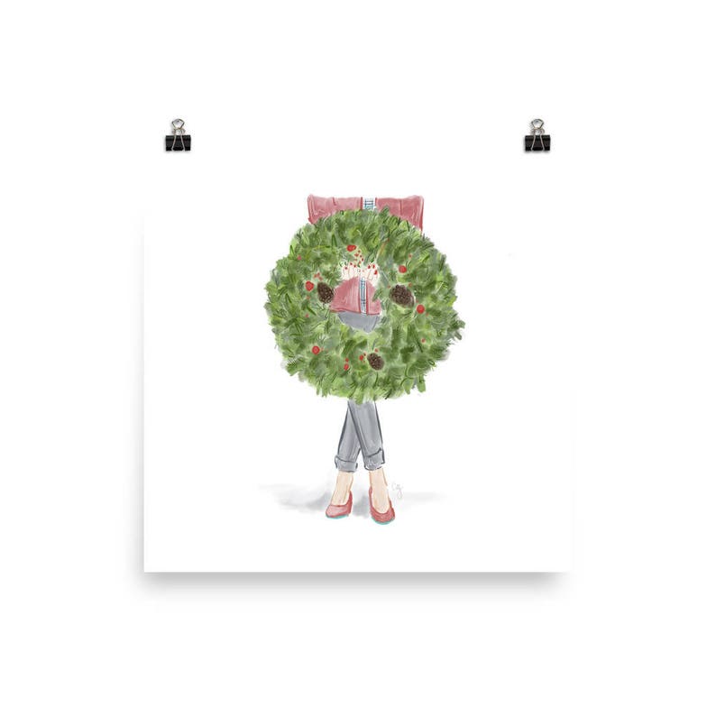 May include: A watercolor illustration of a person wearing a red sweater and jeans standing behind a green Christmas wreath.