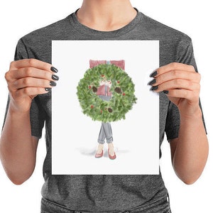 May include: A watercolor illustration of a person wearing a red sweater and jeans with a green Christmas wreath around their head. The person is standing with their arms at their sides.