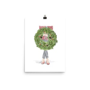 May include: A watercolor illustration of a person wearing a red sweater and jeans holding a green Christmas wreath in front of them.