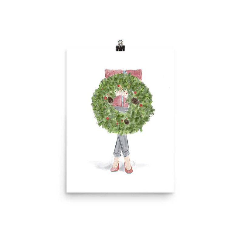 May include: A watercolor illustration of a person wearing a red sweater and jeans holding a green Christmas wreath in front of them.