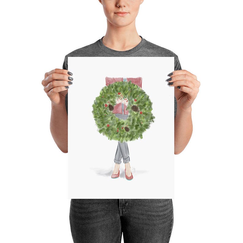 May include: A watercolor illustration of a person wearing a red sweater and jeans holding a green Christmas wreath with red berries and pine cones.