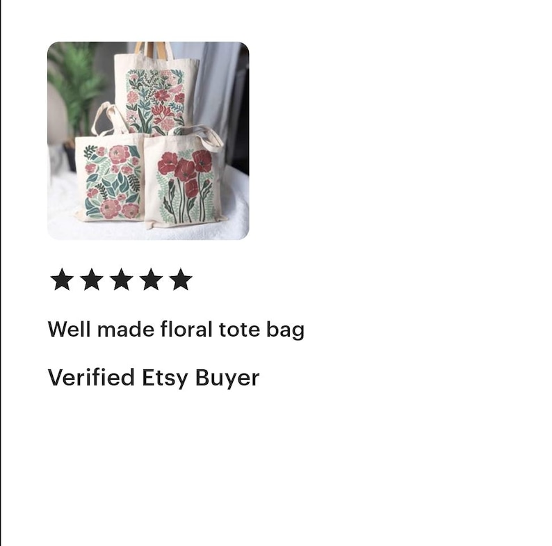 K&ouml;nnte beinhalten: Drei Canvas-Tragetaschen mit floralen Designs. Die Taschen zeigen verschiedene Blumenarrangements in Rot-, Rosa- und Gr&uuml;nt&ouml;nen. Die Taschen haben cremefarbene Griffe und werden auf einer wei&szlig;en Oberfl&auml;che pr&auml;sentiert.