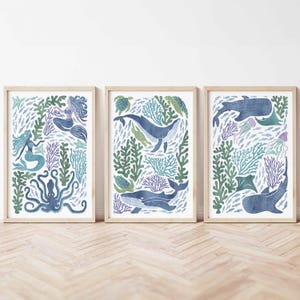 May include: Three framed prints with a blue and green ocean theme. The prints feature mermaids, whales, octopus, sea turtles, and fish. The prints are perfect for a nursery or child's room.