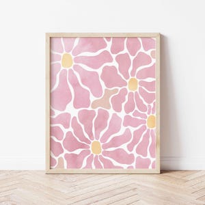 May include: A framed print with a pink and white floral pattern. The flowers have a watercolor effect and have yellow centers.
