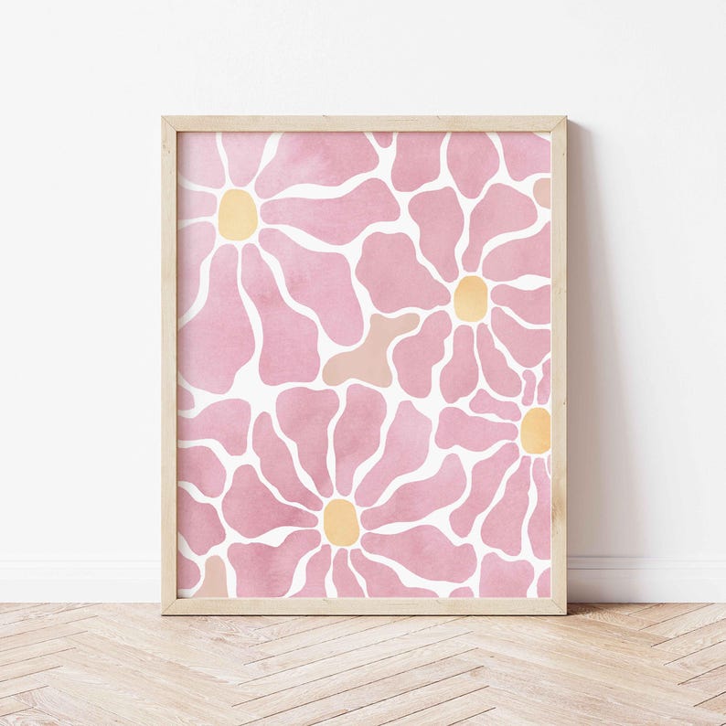 May include: A framed print with a pink and white floral pattern. The flowers have a watercolor effect and have yellow centers.