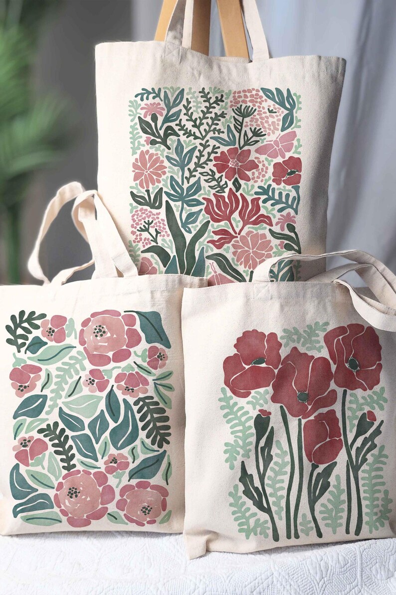 A whimsical floral tote bag with botanical designs in soft pink, light green, and pops of red. One features delicate pink roses with lush greenery, another showcases vibrant red poppies, and the third highlights a spring floral mix with fluttering moths. Perfect for flower lovers, gardeners, and anyone who loves nature-inspired accessories