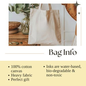 Puede incluir: Una bolsa de lona beige con asas, colgada frente a un fondo neutro. La bolsa est&aacute; hecha de lona 100% algod&oacute;n y tela pesada. Las tintas utilizadas son a base de agua, biodegradables y no t&oacute;xicas. Se muestra el texto "Bag Info".