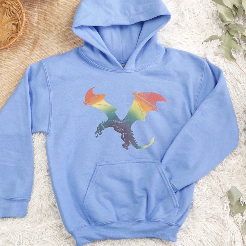 K&ouml;nnte beinhalten: Ein hellblauer Kapuzenpullover mit einem Regenbogen-Drachen-Motiv auf der Vorderseite.