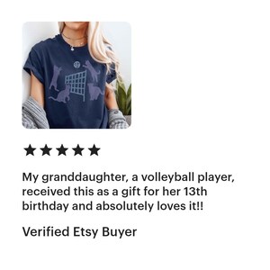May include: A navy blue t-shirt with a volleyball net graphic and cats jumping over the net. The text "My Cats Are Better Than Yours" is printed on the shirt.