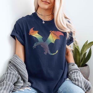 May include: A navy blue t-shirt with a rainbow dragon graphic. The dragon is flying with its wings spread out.