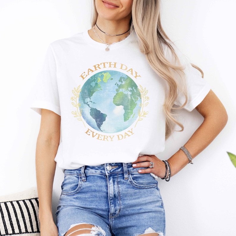 May include: White t-shirt with a graphic of a blue and green Earth with the text "Earth Day Every Day" in gold lettering.