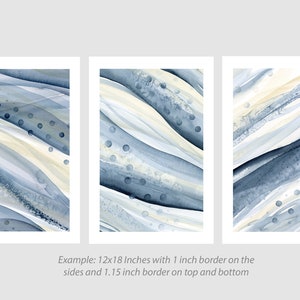 Könnte beinhalten: Drei abstrakte Aquarellbilder in Blautönen und Beige mit weißen Rändern. Jedes Bild zeigt wellenförmige Linien und Punkte.