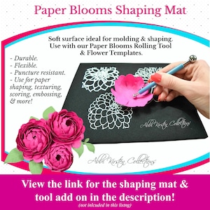 May include: A black foam mat with a white outline of a flower. A pink paper flower is being shaped with a tool. The text "Paper Blooms Shaping Mat" is at the top of the image. The text "Abbi Kirsty Collections" is at the bottom of the image.