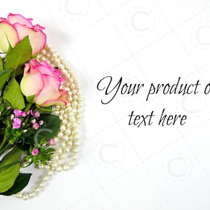 May include: A bouquet of pink and yellow roses with green leaves and small pink flowers, next to a strand of pearls. The text "Your product or text here" is written in black script on a white background.