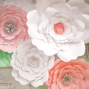May include: Four large paper flowers in shades of pink and white. The flowers are layered and have a delicate, ruffled appearance. The flowers are arranged in a cluster, with the white flowers in the center and the pink flowers on the edges.