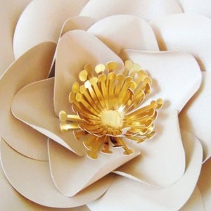 May include: A large, white paper flower with a gold center. The flower has multiple layers of petals and is a popular craft project.