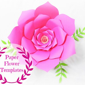 May include: A large pink paper flower with green leaves. The flower is made of multiple layers of paper and has a center that is also made of paper. The text "Paper Flower Templates" is written in a circle around the flower.