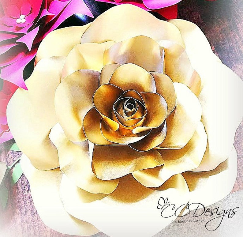 May include: A large, golden paper rose with multiple layers of petals. The rose is a decorative element for a wedding, party, or other special event.