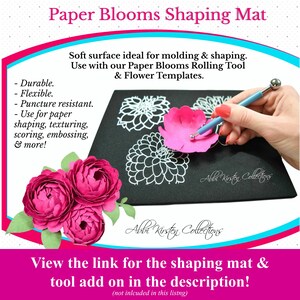 May include: Black foam mat with a white outline of a flower. A pink paper flower is being shaped with a rolling tool. The text "Paper Blooms Shaping Mat" is at the top of the image.