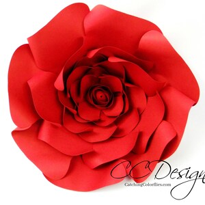 May include: A large, red paper flower with multiple layers of petals. The flower is made of paper and has a realistic appearance.