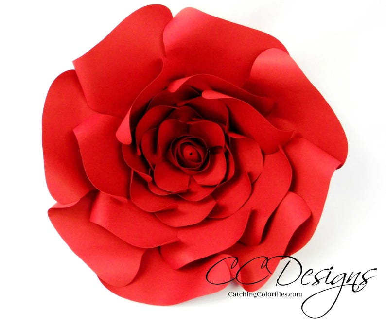 May include: A large, red paper flower with multiple layers of petals. The flower is made of paper and has a realistic appearance.