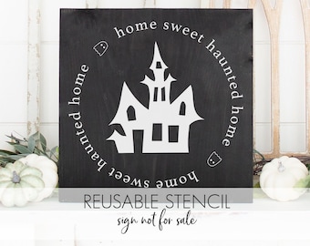 May include: Black and white reusable stencil featuring a haunted house with the text "home sweet haunted home" in a circle around the house.
