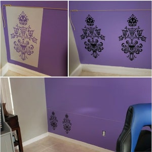 May include: A purple wall with a black and white stencil of a haunted house with owls. The stencil is repeated on the wall in different sizes and positions.