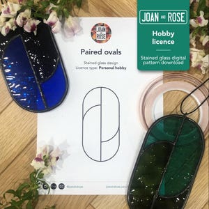 Peut inclure: Un modèle de vitrail pour une paire d'ovales. Le motif est imprimé sur une feuille de papier blanche. Le motif est composé de deux ovales qui se chevauchent, avec une ligne les divisant au milieu. Le motif est entouré d'une bordure noire.