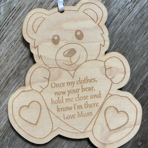 May include: Wooden bear ornament with a heart-shaped cutout that says "Once my clothes, now your bear, hold me close and know I'm there Love Mum".