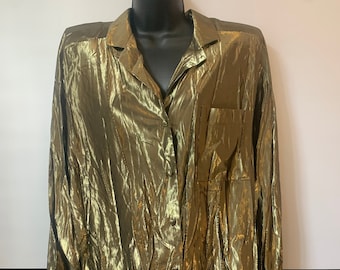 May include: A gold metallic long-sleeved button-up shirt with a single pocket on the left side.