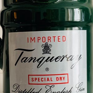 May include: A green ceramic bottle with a red top. The label reads "IMPORTED Tanqueray SPECIAL DRY Distilled English Gin." The bottle is from Charles Tanqueray & Co Ltd, London, England. The product is made in England.