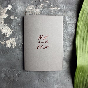 May include: A gray card with the words "Mr and Mr" written in red foil lettering.