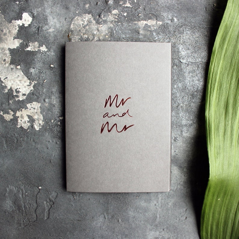 May include: A gray card with the words "Mr and Mr" written in red foil lettering.