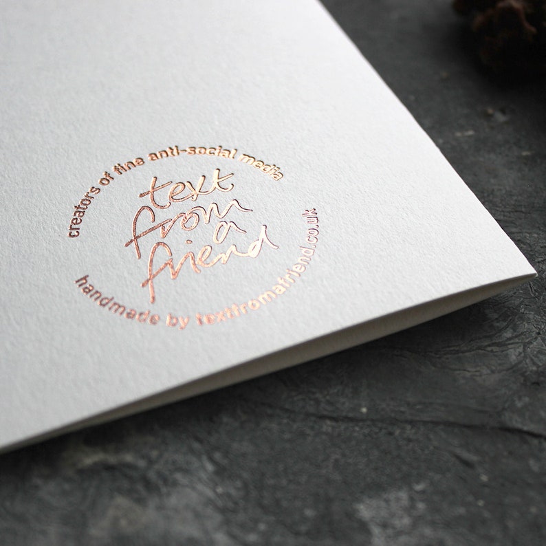 May include: A white card with a rose gold circle logo that says "creators of the anti-social media text from a friend handmade by textfromafriend.co.uk"