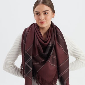 May include: A burgundy and black plaid scarf with fringe. The scarf is made of a soft, warm material and is perfect for keeping you warm in the winter.