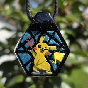 Colgante de Pikachu en capas de vidrio fundido reactivo a los rayos UV que brilla en la oscuridad