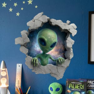 May include: A green alien figure with large blue eyes appears to be breaking through a wall, surrounded by a cracked, gray frame. The background reveals a galaxy. Decorative star stickers are on the blue wall. A small green alien plush toy is on a shelf.