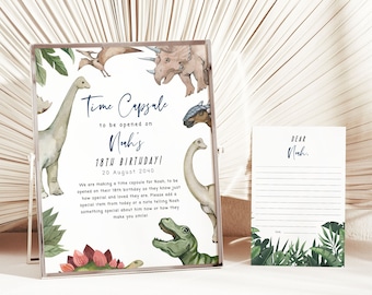 May include: A white card with a dinosaur theme, with the text "Time Capsule to be opened on Noah's 18th Birthday! 20 August 2040". The card has a green and white card with the text "Dear Noah."