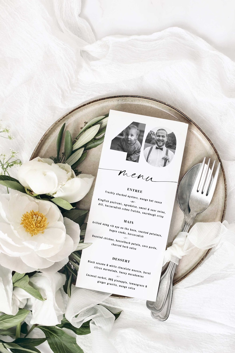 May include: A black and white menu card with a photo of a man and a child. The menu card has the number 40 on it and lists the menu items for an event. The menu items include entrees, main courses, and desserts.