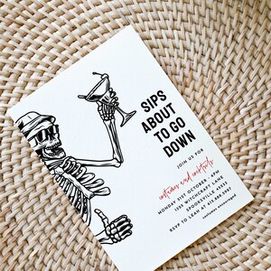 May include: A black and white illustration of a skeleton holding a martini glass. The text "Sips About To Go Down" is written in black. The text "Join us for costumes and cocktails" is written in red. The text "Monday 31st October 6pm" is written in black. The text "1325 Witchcraft Lane" is written in black. The text "Spooksville 45233" is written in black. The text "RSVP to Leah at 615.588.5987" is written in black. The text "costumes encouraged" is written in red.
