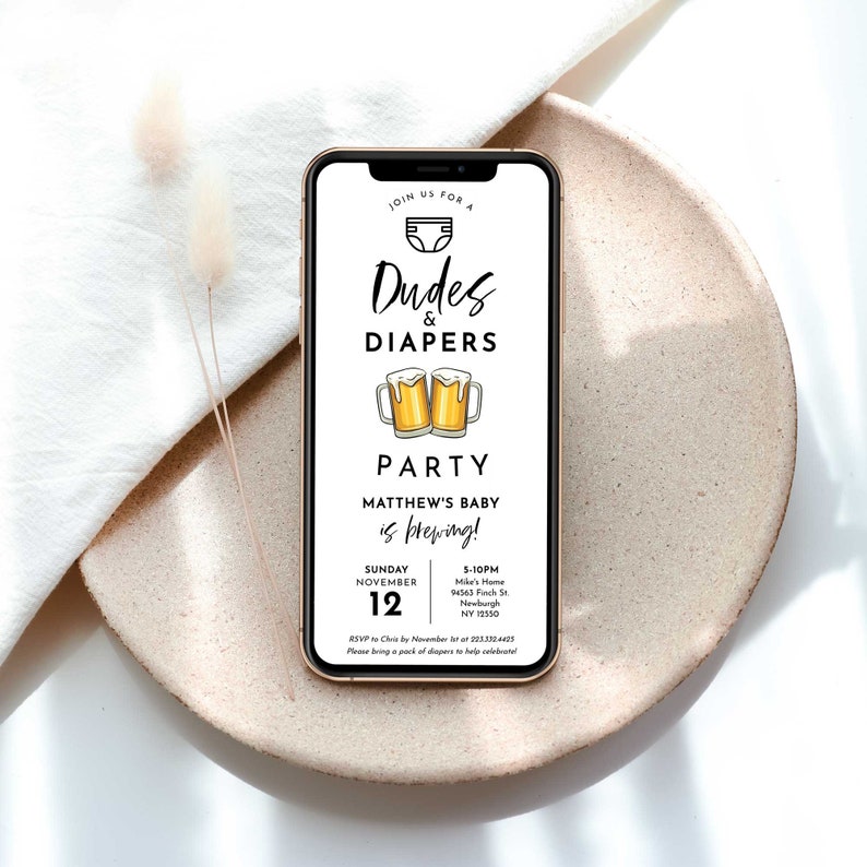 以下が含まれることがあります： 「Dudes & Diapers Party」というテキストと2つのビールジョッキのグラフィックが描かれた、ベビーシャワーパーティーのデジタル招待状。招待状には、パーティーの日時と場所が記載されています。RSVP情報も含まれています。