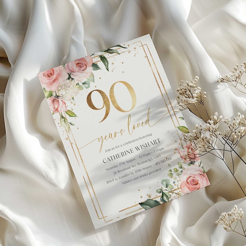 May include: A gold and white invitation card with a floral design and gold lettering. The text reads "90 years loved" and "Join us for a celebration honoring Catherine Wishart".