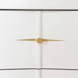 May include: White dresser drawer with a gold knob and a thin gold line across the front.