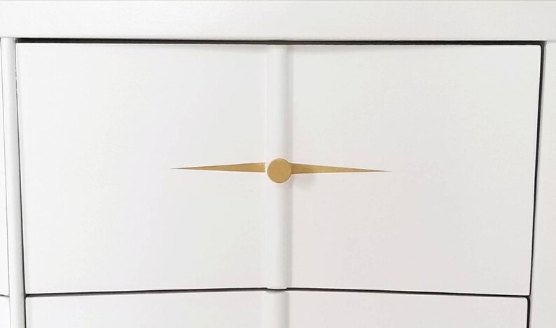 May include: White dresser drawer with a gold knob and a thin gold line across the front.
