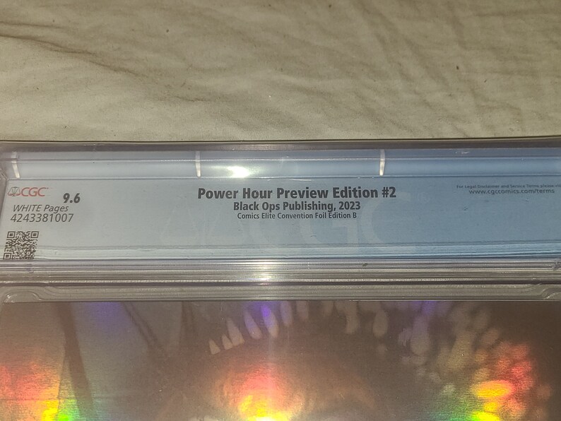 May include: A CGC graded comic book with a 9.6 rating. The comic is titled "Power Hour Preview Edition #2" and is published by Black Ops Publishing in 2023. The comic is a Comics Elite Convention Foil Edition B.