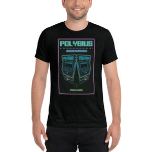 May include: Black t-shirt with a neon green and purple graphic. The graphic features the word "POLYBIUS" above two arcade game machines. The text "PRESS START!" is at the bottom of the graphic.