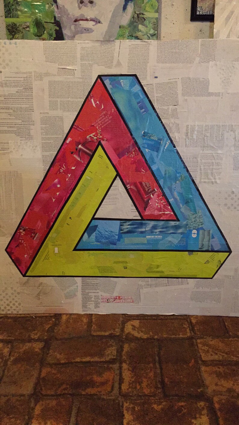 May include: A colorful, optical illusion triangle made of paper, with red, blue, and yellow sections. The triangle is on a white background with a newspaper-like texture.