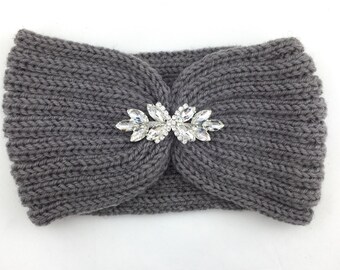 May include: Gray knitted headband with a large, clear rhinestone embellishment in the center.