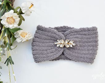 May include: Gray knitted headband with a crystal embellishment in the center.