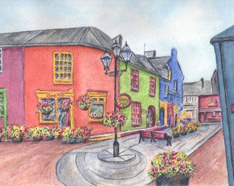 May include: Watercolor painting of a colorful street scene with buildings in shades of red, green, and blue. The buildings have yellow-framed windows and hanging flower baskets. The street has a cobblestone appearance, and a street lamp stands in the center.